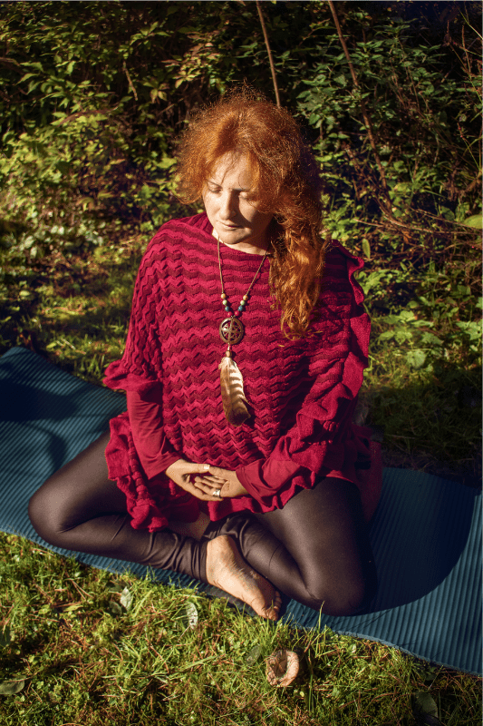 Sarah Stulzaft Vitalenergy en méditation assise en lotus sur un tapis de yoga en extérieur, séance de yoga bien-être et relaxation, cours de yoga à Lille en plein air.