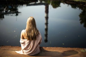 se reconnecter à soi par la présence, femme en méditation, contemplant le reflet de la ville et de la nature sur l'eau