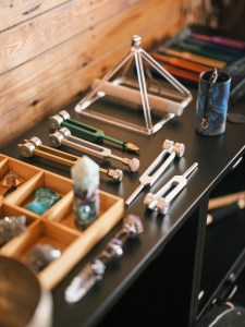 Matériel de sonothérapie professionnel : diapasons lestés, cristaux et pyramide en cristal, sujets abordés lors d'un mentorat avec Sarah à Lille.